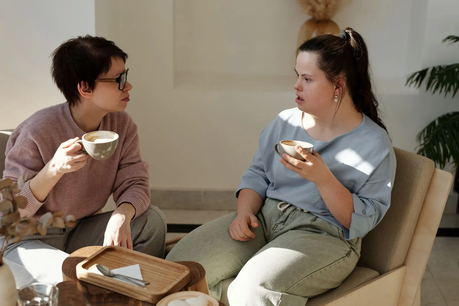 Twee vrouwen ontbijten samen en praten; de vrouw rechts heeft het syndroom van Down